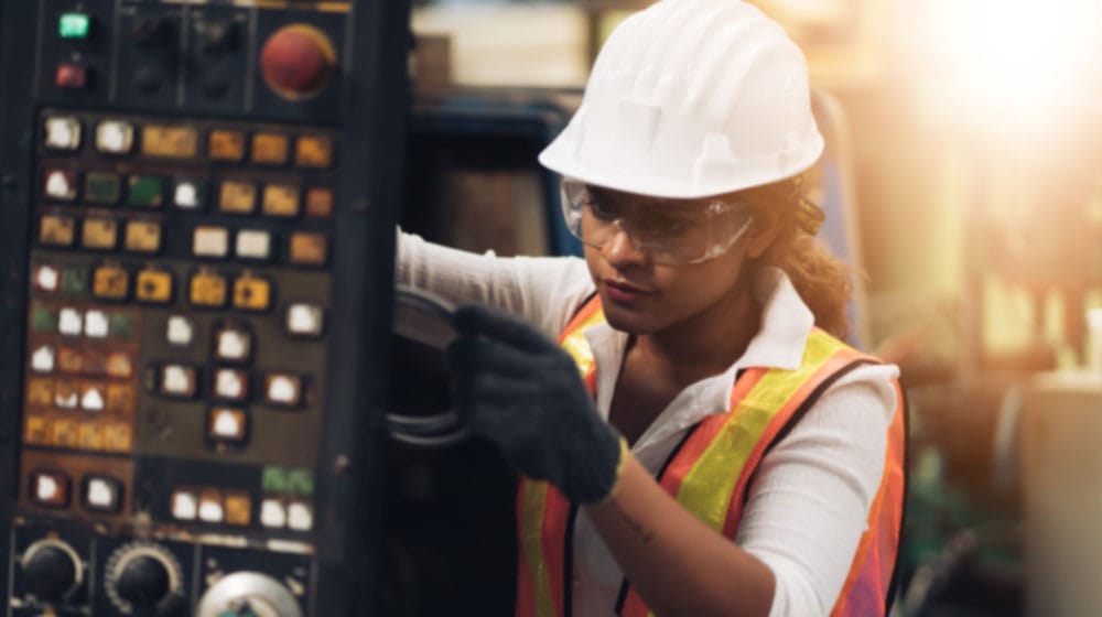 woman in hard hat working on electrical equipment
