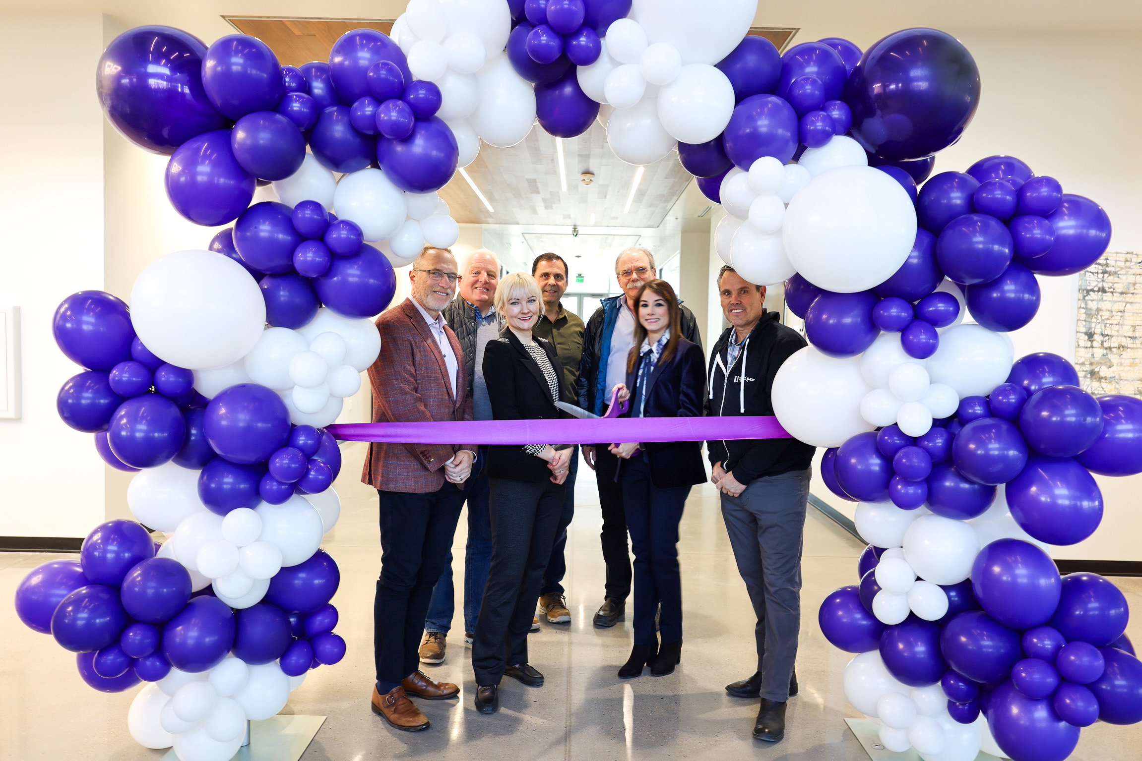 A group of people cutting a ribbon